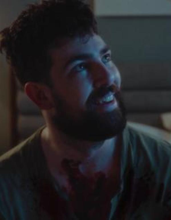 director, Danny Whalen in a still from a movie, looking up and smiling sadly