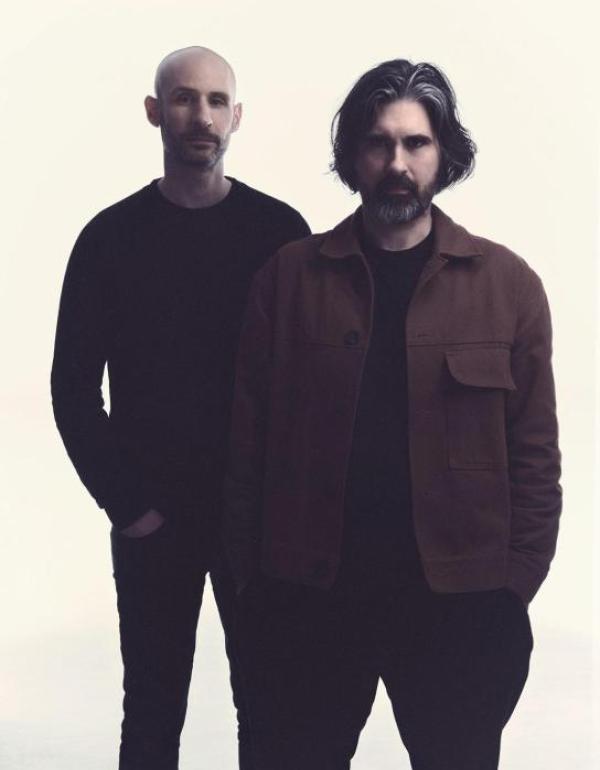 Two men stand glaring at the camera while they think about conquering the world