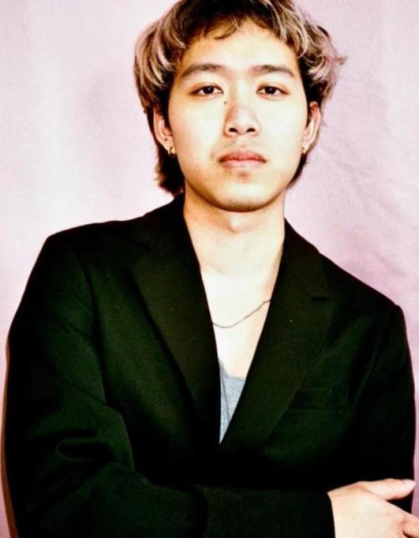 Headshot portrait of Joel Nasan Roberson, Thai-American Filmmaker against a pink backdrop