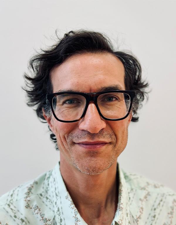A front facing headshot in glasses of director Kevin Ignatius.