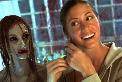 A woman looks in the mirror and a ghost does too.