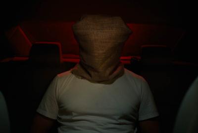 A man's head is covered with a bag