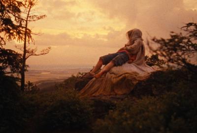 A woman lies on the lap of Morana over the sunset.
