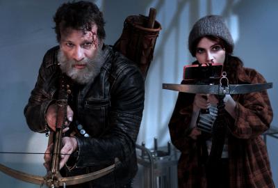 Man and young woman point cross bows