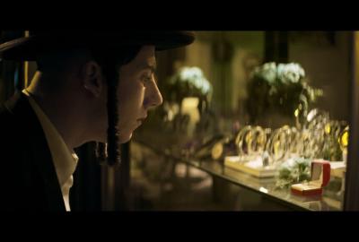 Moishi  looks at a ring in the window of a jewelry store