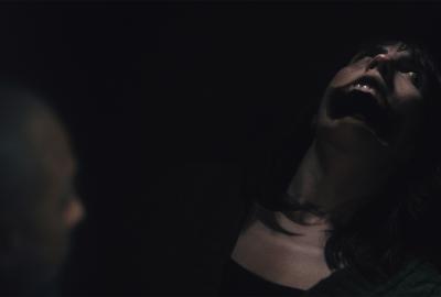 A boy looks in terror at a monstrous person with a huge mouth.