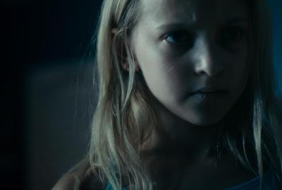 A young girl looks on