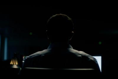 A man looks at a computer monitor