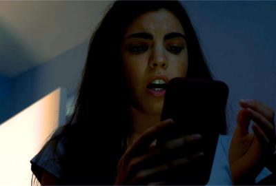 Kim looks at her phone