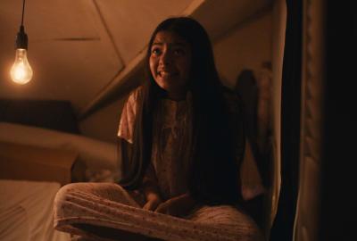 A young girl looks on in fear