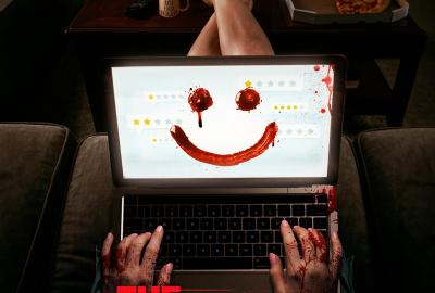 Horror film poster featuring a food critic typing on a laptop with blood-covered hands, as a bloody smiley face appears across online reviews on the screen.