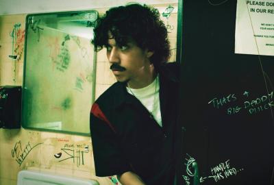 Gas station worker enters bathroom cautiously.