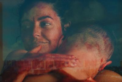 A couple hugs in a window