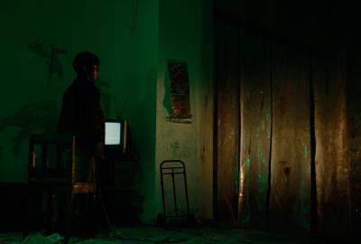 Car headlights shine on Andrés, the protagonist, as he awaits the return of The Butcher.