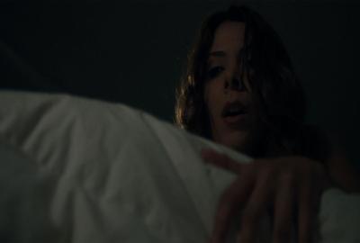 Alone woman looks over bed