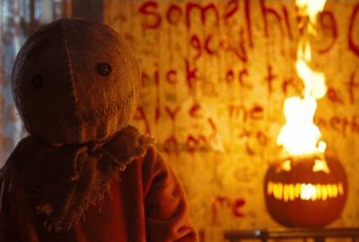Sam looks on with pumpkin on fire behind him