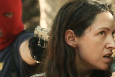 ZTV Sympathy for the Devil film still masked man pointing gun to woman's head.